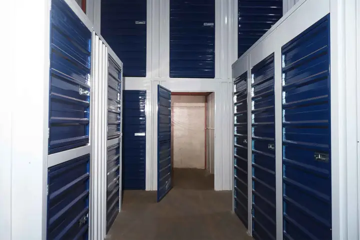 Corredor interno com boxes de portas azuis